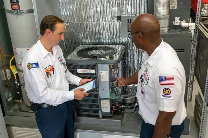 HVAC technicians inspecting an air conditioner